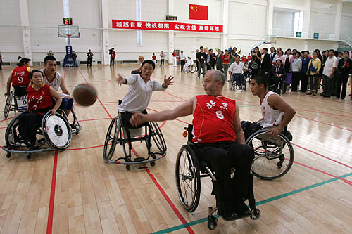 图为克雷文与轮椅篮球运动员一起打轮椅篮球