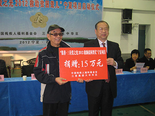 图为:邢建绪副理事长代表中国残疾人福利基金会向宁夏贫困聋儿捐赠15万元助听资助款