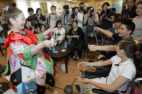 图为魔术师与在京康复治疗的地震灾区残疾少年互动表演魔术