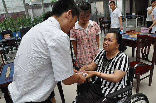图为中国残疾人福利基金会工作人员向刘芳英、孟佩杰母女送去慰问金