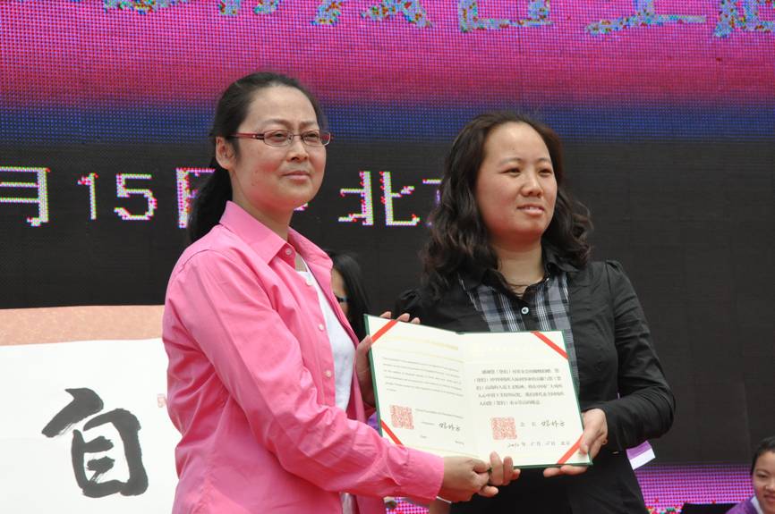 图为中国残疾人福利基金会秘书长费薇向爱心人士颁发捐赠证书