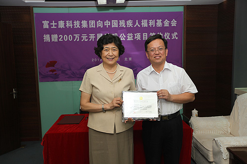 图为：汤小泉理事长向富士康科技集团回赠荣誉牌匾
