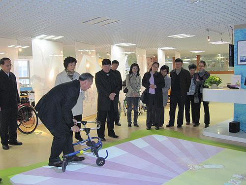 图为汤小泉理事长参观中国残疾人辅具中心辅助器具展厅