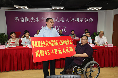 图为季益顺先生向中国残疾人联合会吕世明副主席递送捐赠牌匾
