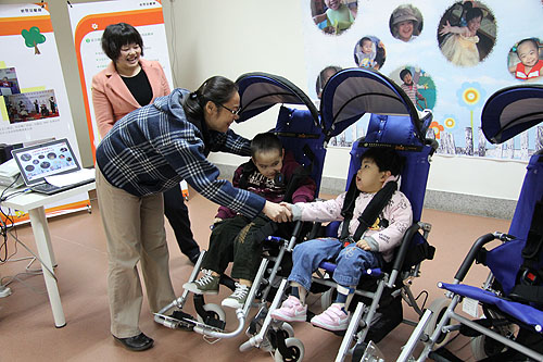 费薇副理事长与接受我会捐赠轮椅的儿童握手