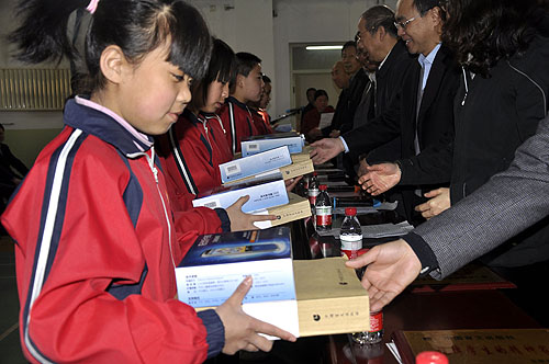 图为太原盲校学生接受中国银联捐赠的盲文图书和电子听书机