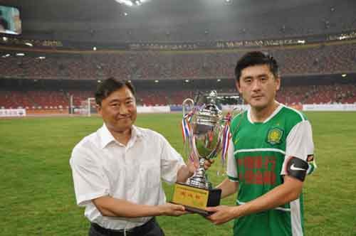 图为国家体育总局足球运动管理中心副主任、中国足协副主席于洪臣向北京国安足球俱乐部颁发“爱心奖杯”