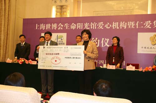 图为上海仁爱医院施龙飞院长向汤小泉理事长递送象征性捐赠支票