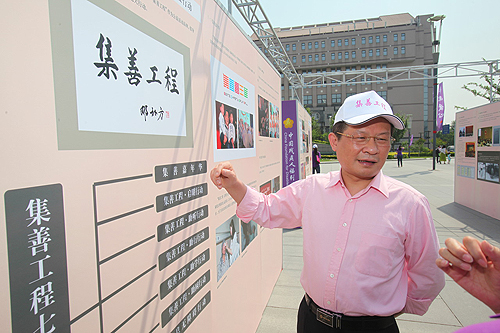 图为中国残联副主席、党组副书记、常务副理事长孙先德参观集善工程图片展