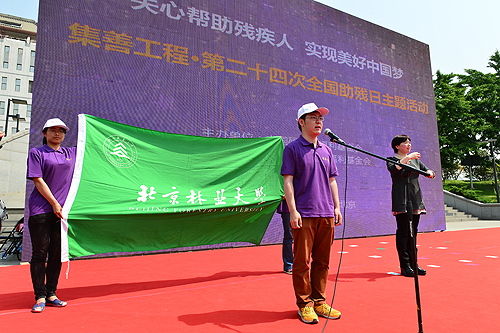 图为林业大学助残志愿者宣读助残志愿倡议书