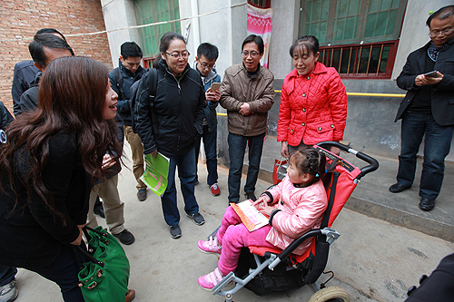 图为费薇副理事长、李笑梅副主任一行探访残疾儿童家庭