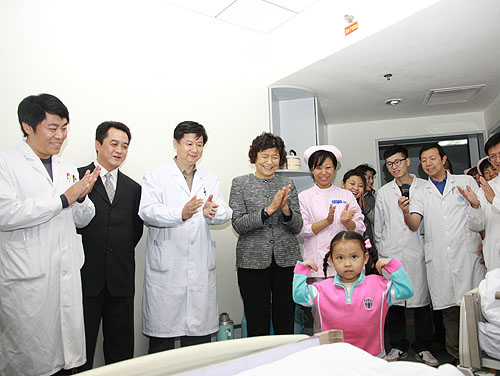 图为2010年，中国残疾人福利基金会汤小泉理事长在中国康复研究中心看望四川灾区小朋友