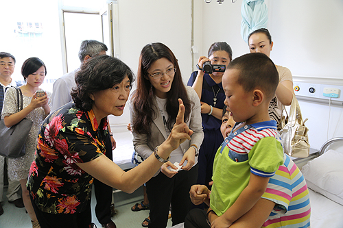 图为中国残疾人福利基金会理事长汤小泉看望受助儿童