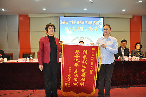 图为中国残疾人福利基金会副理事长费薇接受锦旗