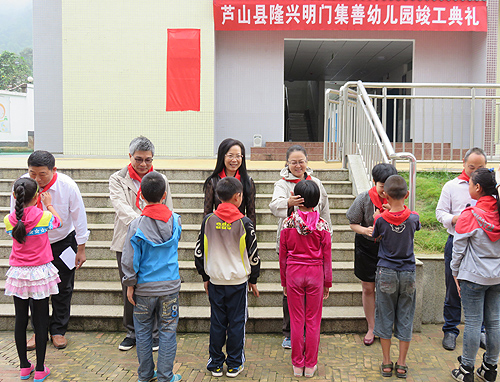 图为隆兴中心校少先队员向出席幼儿园竣工仪式的领导敬献红领巾