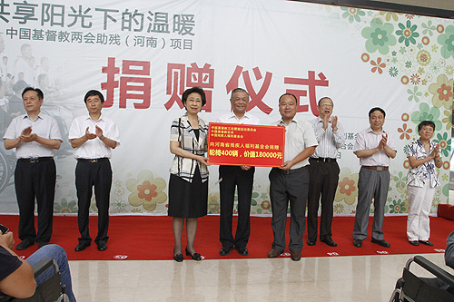 图为王乃坤理事长、傅先伟长老向河南省残疾人福利基金会捐赠400辆轮椅
