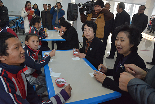 图为王乃坤副主席、苏宁常委共同与残疾儿童品尝蜜儿餐