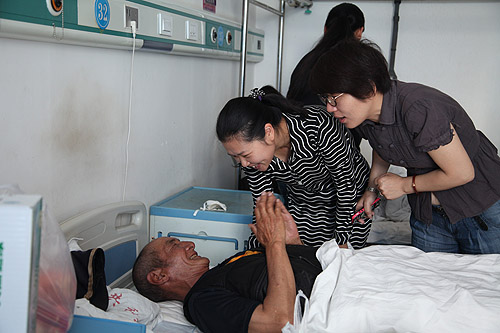 图为中国进出口银行计划财务部总经理助理王欣看望术后贫困白内障患者