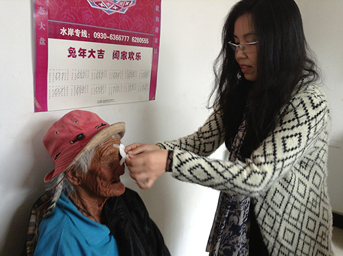 图为佳通集团法务总监寿惠多女士为术后贫困白内障患者揭纱布