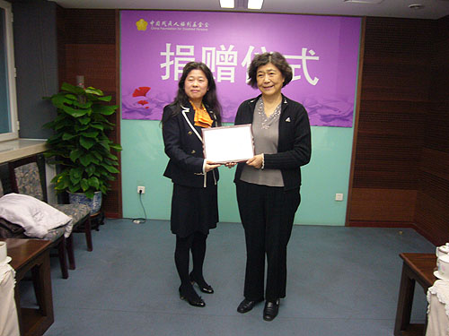 图为北京艾美奥医学科技有限公司总经理张哲琴接受汤小泉理事长回赠的荣誉证书