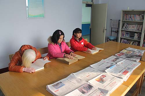 山东省泰安市盲人学校学生在阅览室触摸盲书