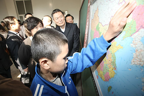 图为汤小泉理事长与苏宁董事长在教室观看盲校学生使用语音地图
