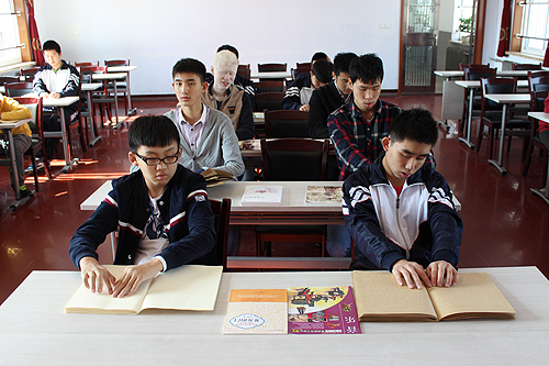 辽宁省丹东市特殊教育学校学生在认真触摸盲书