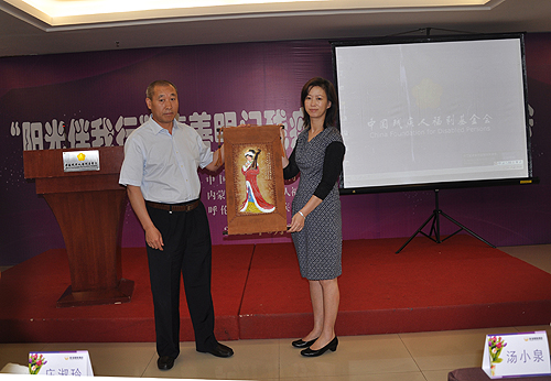 图为受助机构代表向明门集团副总经理庄淑玲赠送纪念品