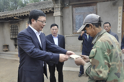 图为上海市嘉定区江桥镇书记袁航为陇西县残疾人家庭送去慰问金