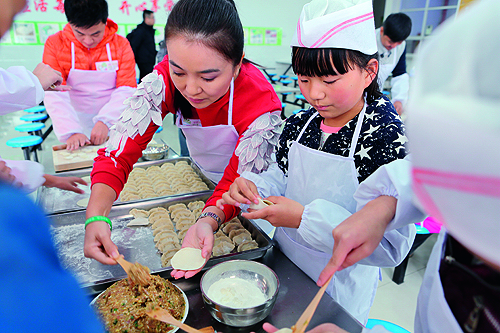 图为周洲在与残疾儿童一起包饺子